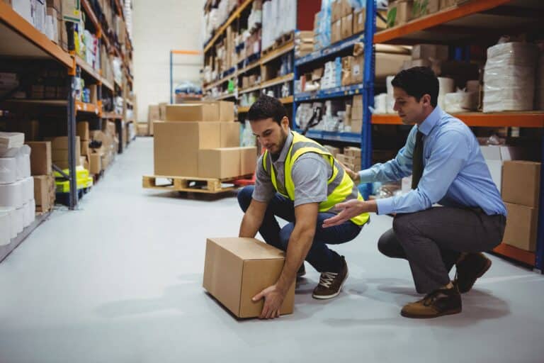 Man picking up box in warehouse distribution center