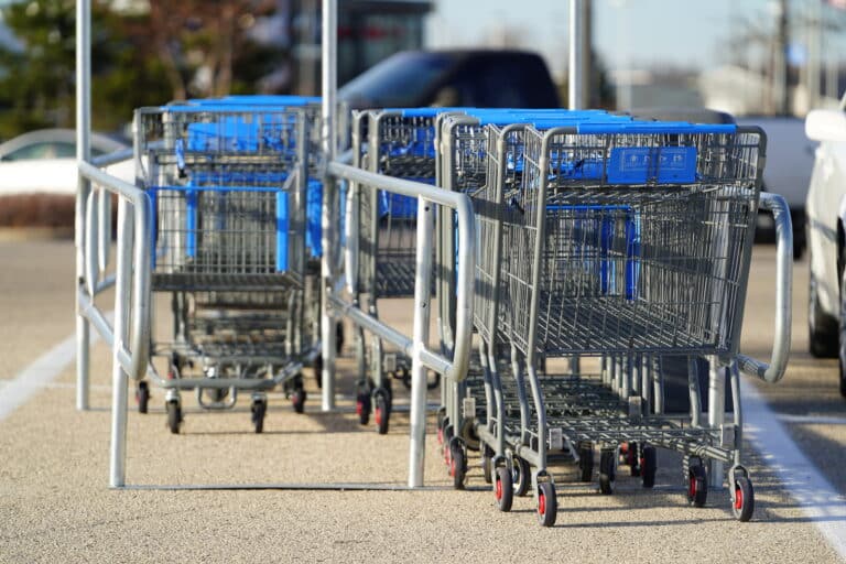 Shopping carts neatly stored in a custom cart corral, showcasing the power of enhancing convenience and order in retail with Nutting Carts and Trailers.