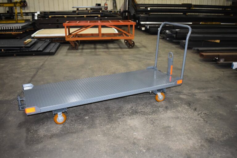 Hybrid steer pallet cart transporting auto parts in manufacturing facility
