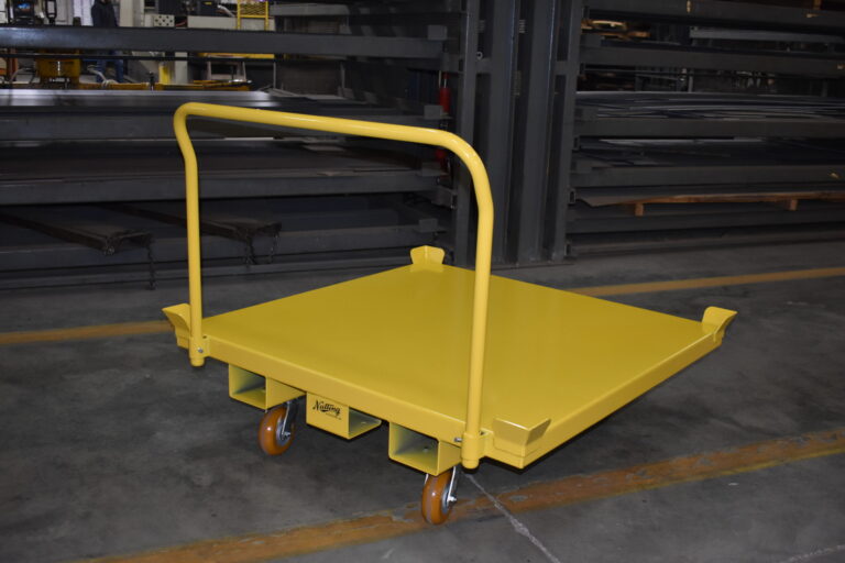 Steel push cart moving crated automotive parts along an assembly line