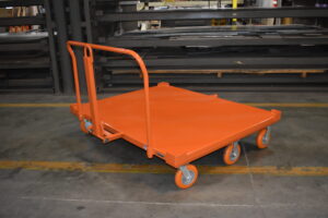 Six wheel pivot steer pallet cart turning sharply through an automotive plant